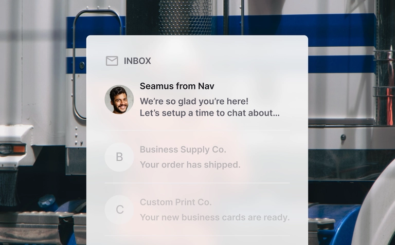 Inbox message from Seamus at Nav welcoming a member, displayed over a trucking warehouse background.
